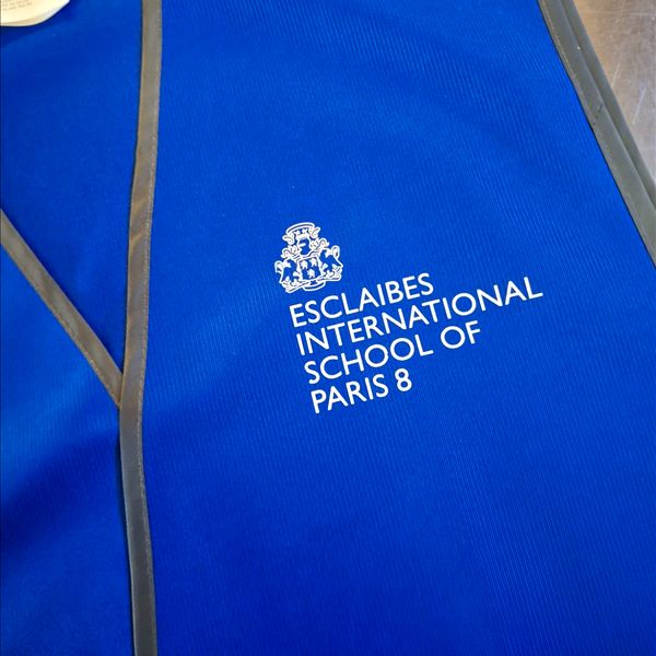 Exemple de marquage au cœur sur gilet R200 Gilet R200 bleu royal personnalisé avec le blason d'une école internationale imprimé au cœur