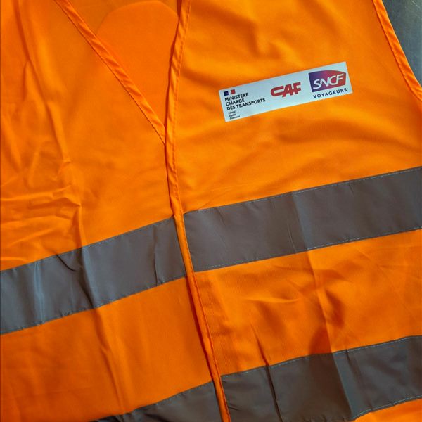 Gilet de sécurité orange 2 bandes Yoko HVW102 personnalisé au cœur avec les logos du Ministère chargé des Transports, de CAF et de SNCF Voyageurs